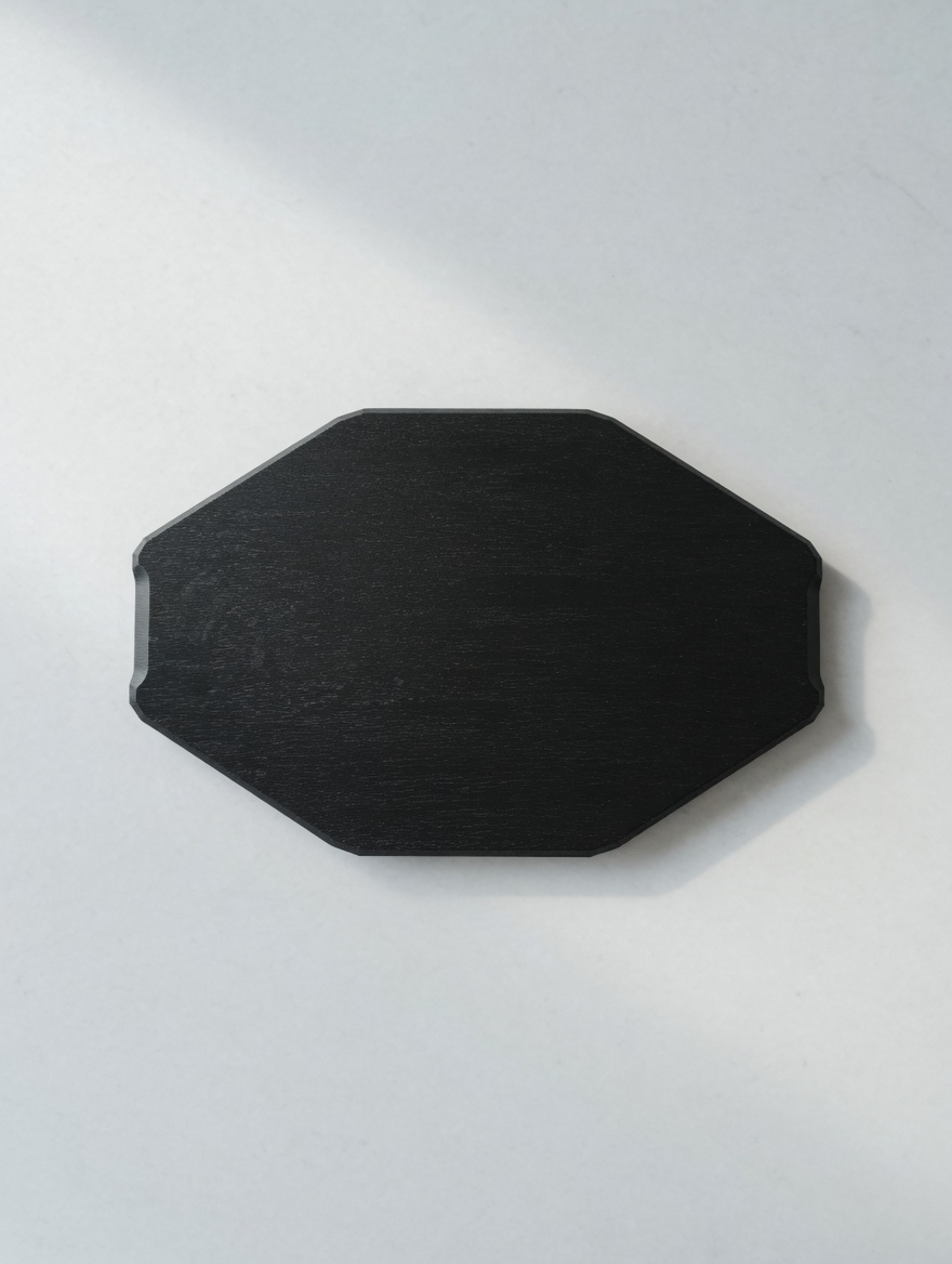 An octagonal blackened oak platter, top-down