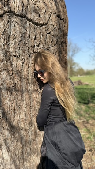 Ekaterina, in profile, against the tree